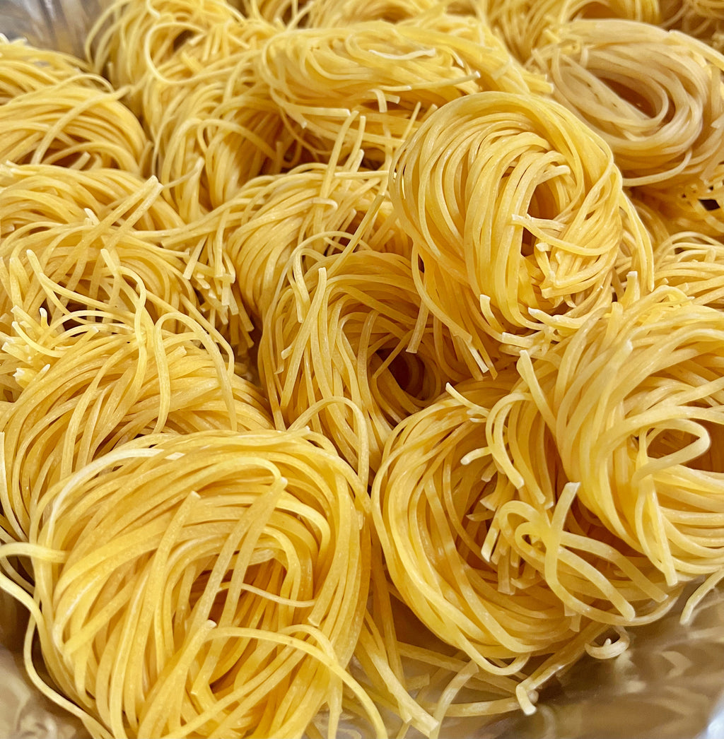 Close-up of uncooked linguine noodles on a metallic surface
